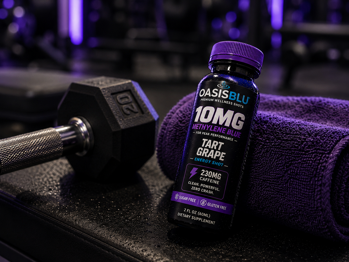 Oasis Blu energy shot bottle with a dumbbell and towel in a gym setting